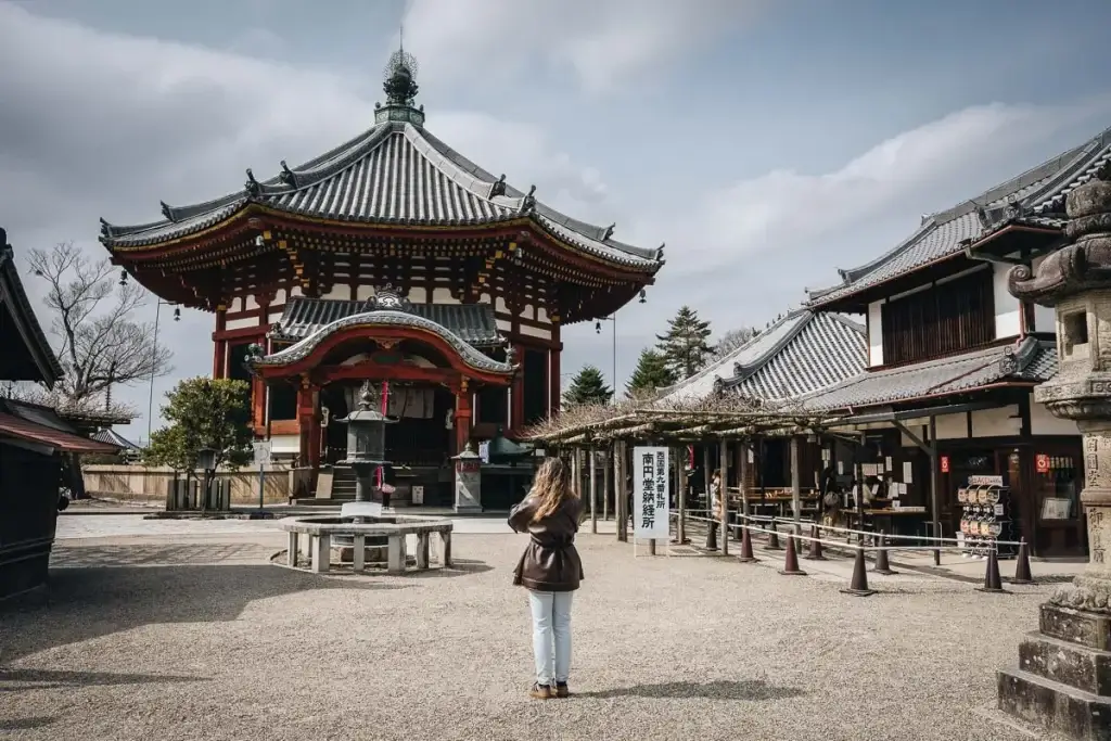 Jeune femme photographiant le pavillon octogonal Nan'endō du temple Kōfuku-ji à Nara