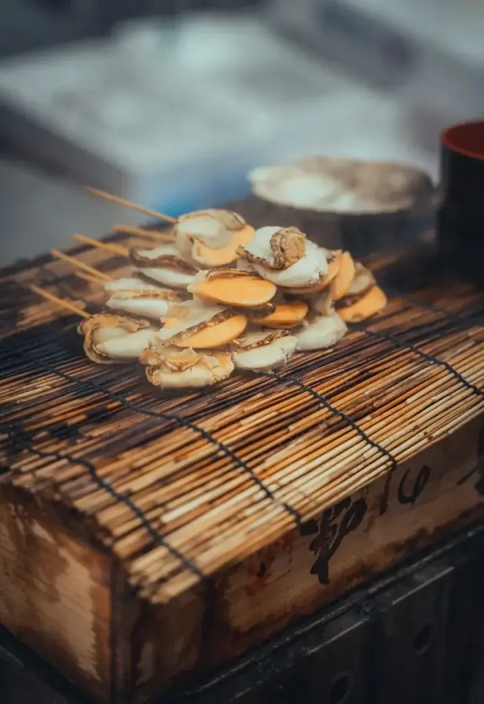 Brochettes de noix de Saint-Jacques grillées sur un stand du marché Kuromon