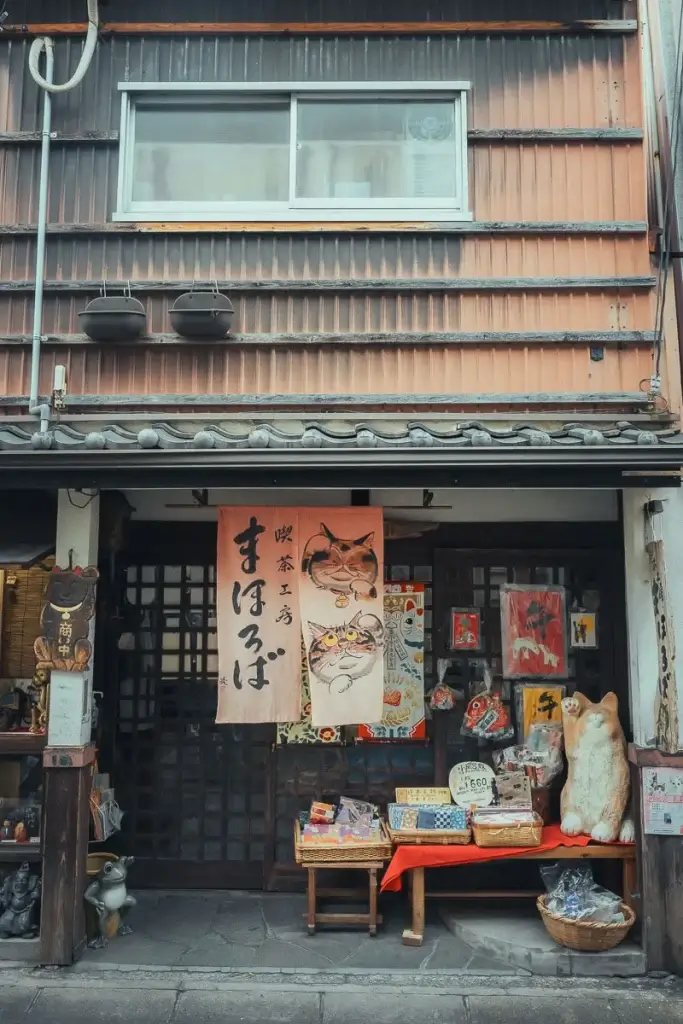 Façade en bois d'une boutique ornée de rideaux noren aux chats dans le quartier de Naramachi à Nara