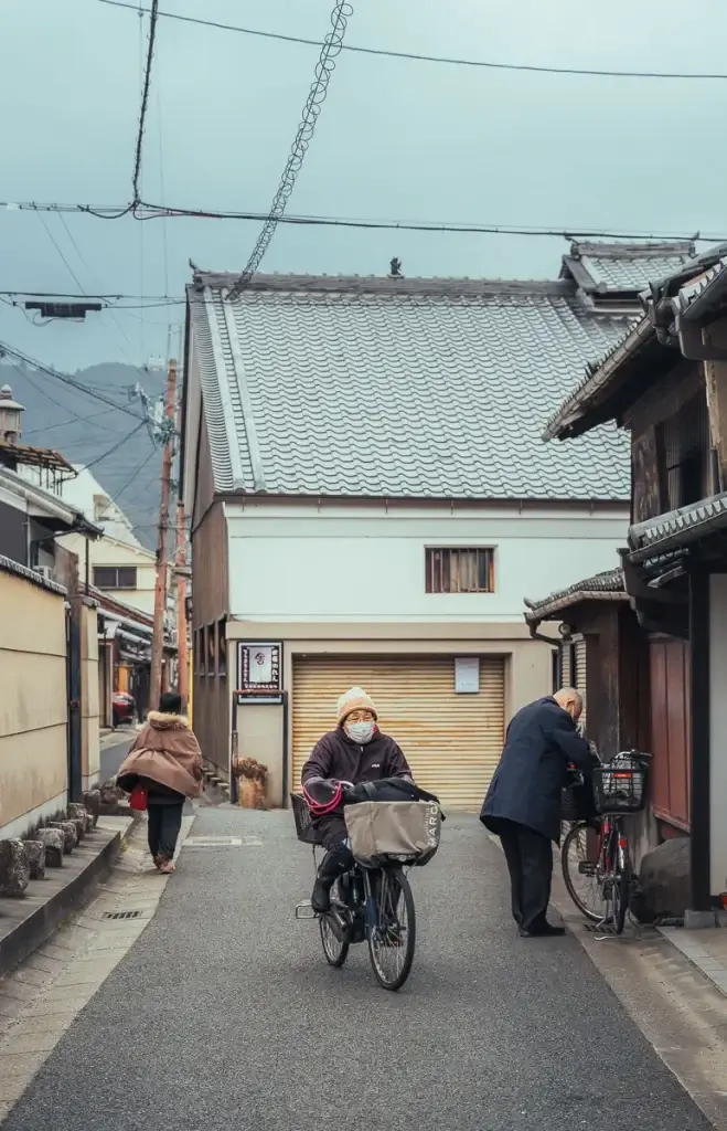 Habitante à vélo dans une ruelle du quartier de Naramachi à Nara